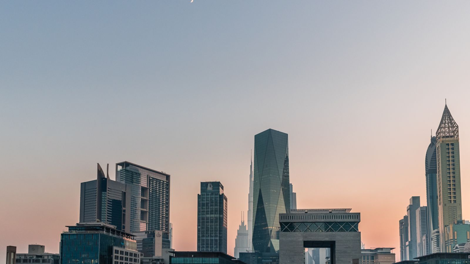 Dubai business district towers and gate at sunset
