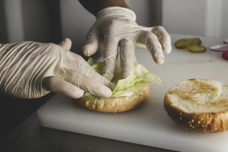 Food handler wearing gloves preparing food - food workers in Dubai need an Occupational Health Card