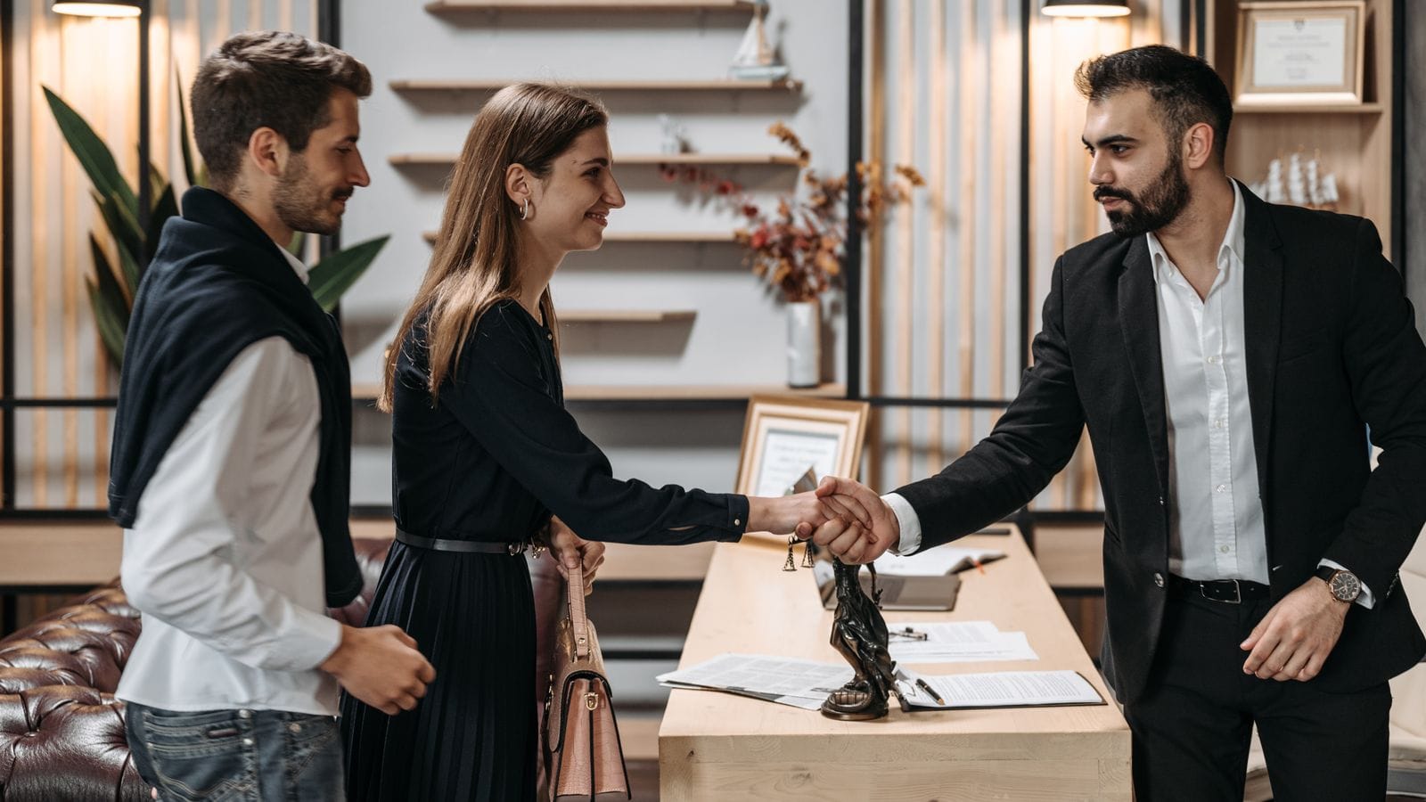 Professionals shaking hands on a new hire in a modern office