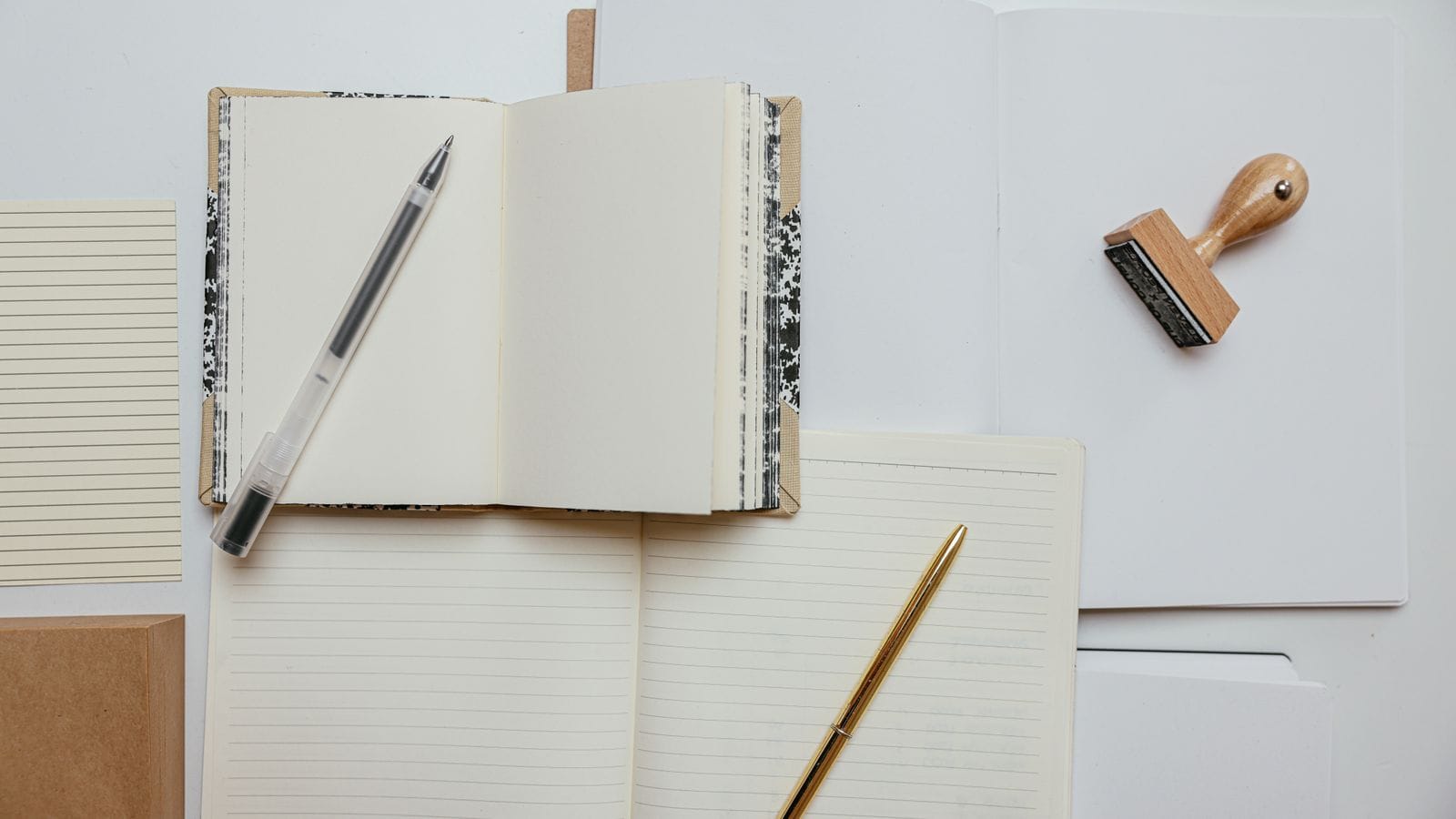 Rubber stamp resting on an open notebook on a white desk, suggesting official document stamping